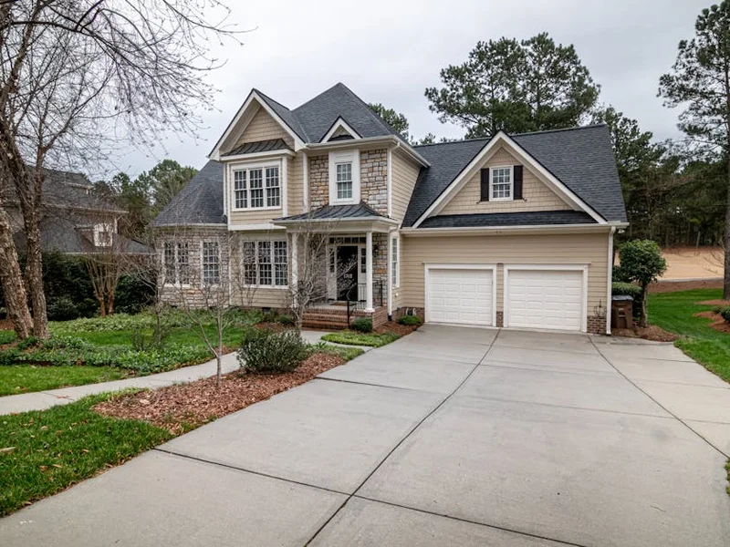 Charming suburban home featuring a two-car garage, manicured lawn, and inviting entrance.
