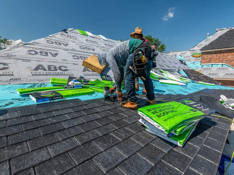 Workers installing a synthetic slate roof on a brick house in Fort Worth, Texas.