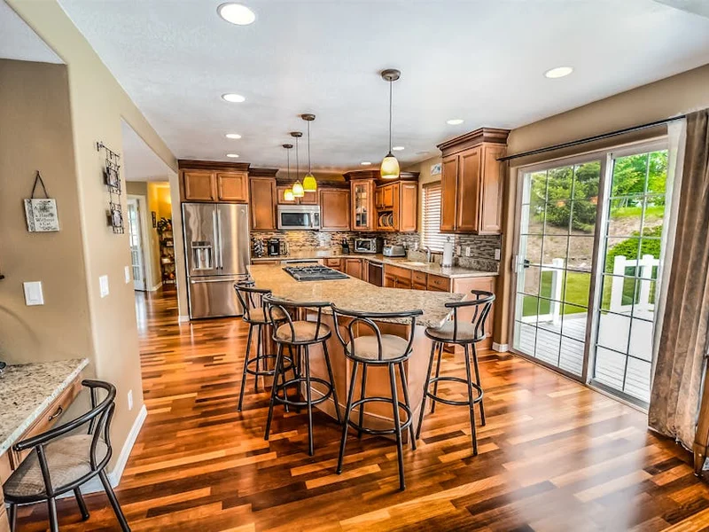 A luxurious modern kitchen featuring hardwood floors and granite countertops.